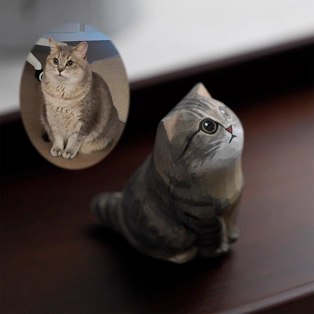 A fluffy, cute cat with a little wooden statue exactly like her next to it