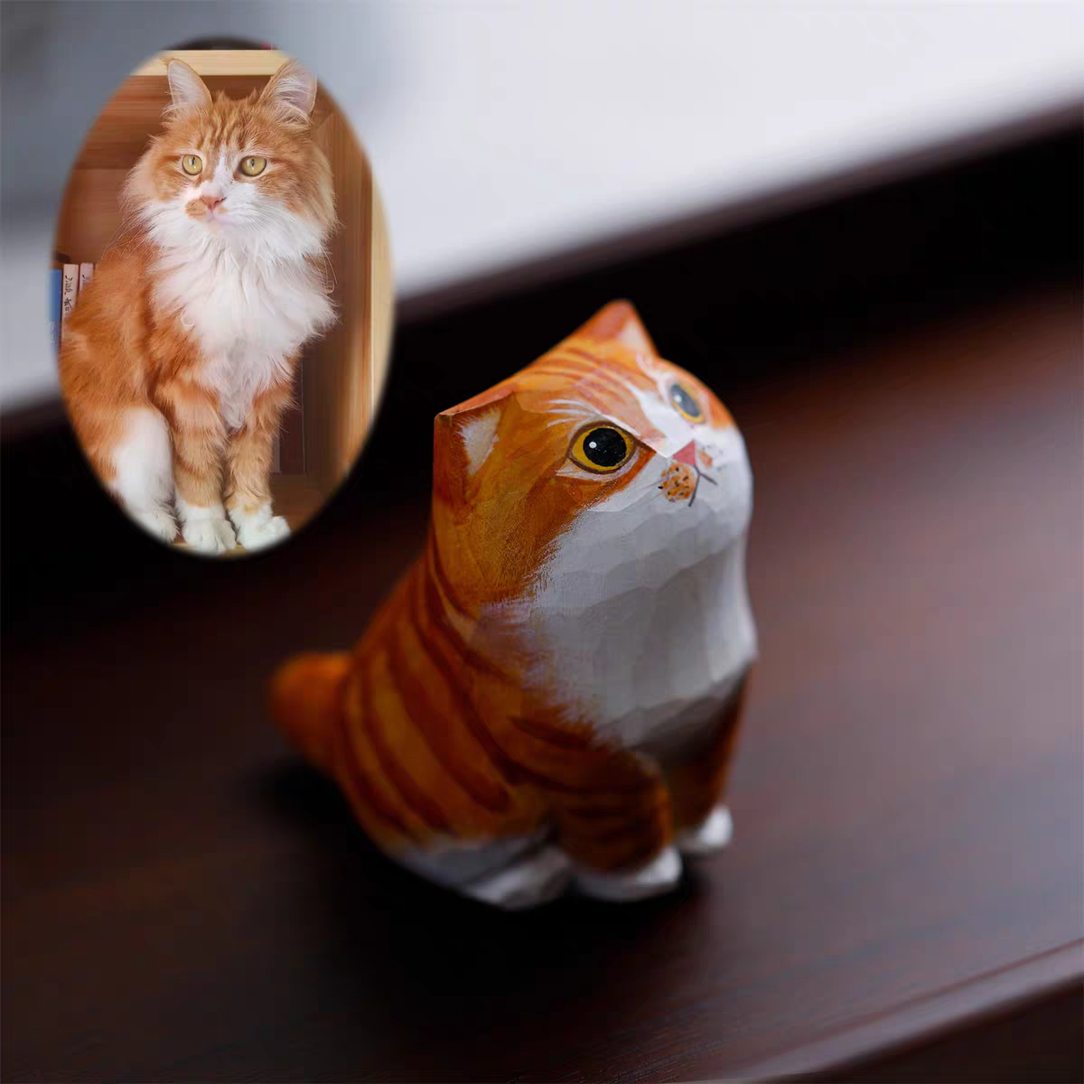 A fluffy, cute cat with a little wooden statue exactly like her next to it