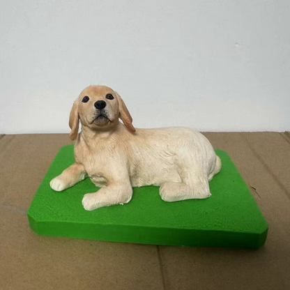 A soft ceramic sculpture of a golden dog lying on the ground
